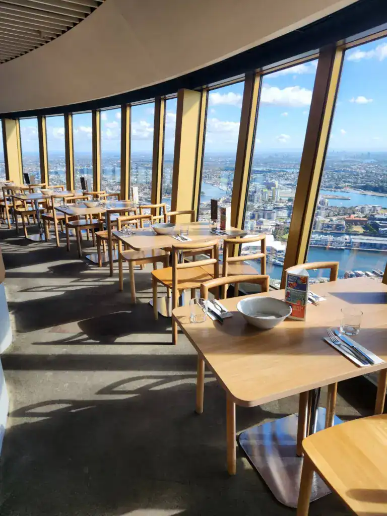 雪梨塔旋轉餐廳室內用餐區，靠窗座位可俯瞰雪梨市區與港灣景色